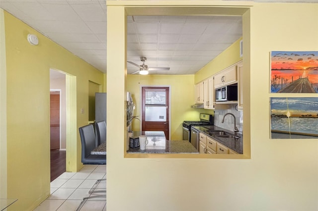 kitchen with ceiling fan, built in microwave, sink, light tile patterned floors, and stainless steel gas stove