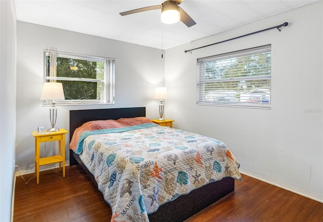 bedroom with ceiling fan, dark hardwood / wood-style floors, and multiple windows