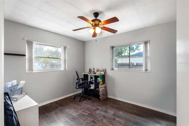 office featuring dark wood-type flooring, ceiling fan, and a healthy amount of sunlight