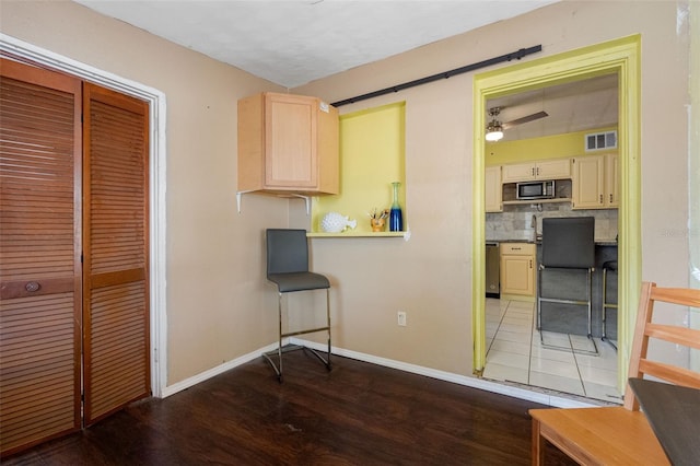 kitchen with stainless steel dishwasher, decorative backsplash, ceiling fan, and dark hardwood / wood-style flooring