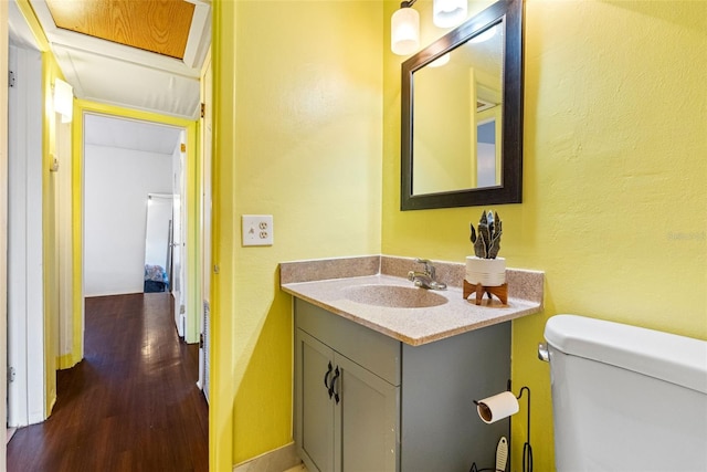 bathroom with hardwood / wood-style flooring, vanity, and toilet