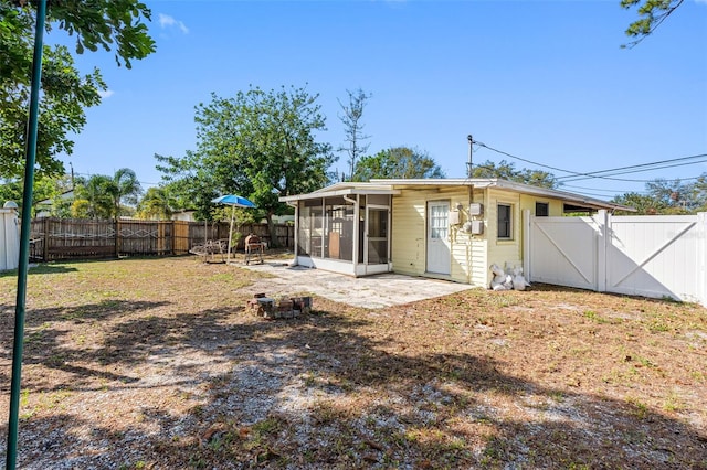 rear view of property with a sunroom and a patio