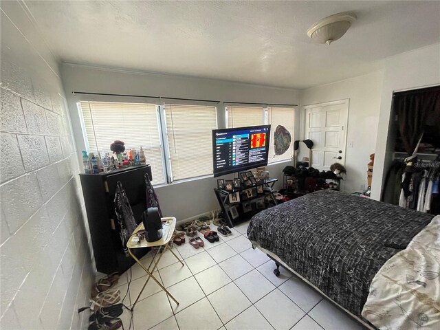 tiled bedroom with a closet