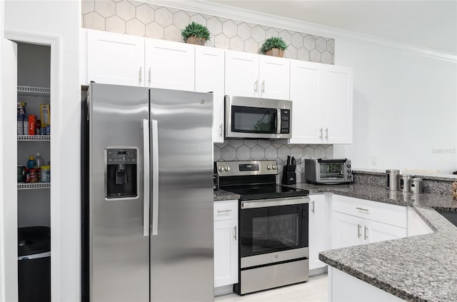 kitchen with crown molding, white cabinetry, and stainless steel appliances