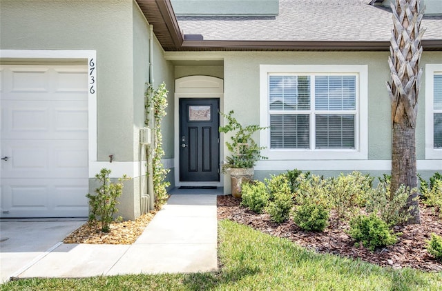 doorway to property featuring a garage, roof with shingles, and stucco siding