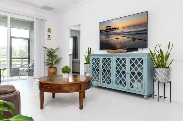 living area featuring a healthy amount of sunlight, crown molding, and visible vents