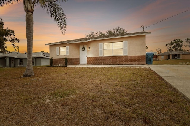 ranch-style home with a lawn