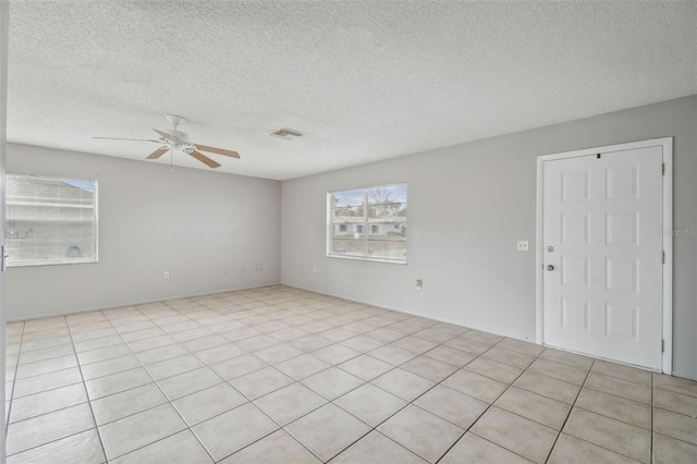 unfurnished room with light tile patterned floors, a textured ceiling, and ceiling fan