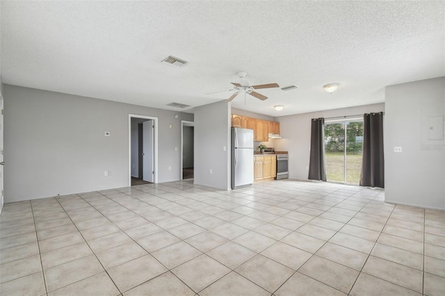 unfurnished living room with ceiling fan, light tile patterned floors, and a textured ceiling