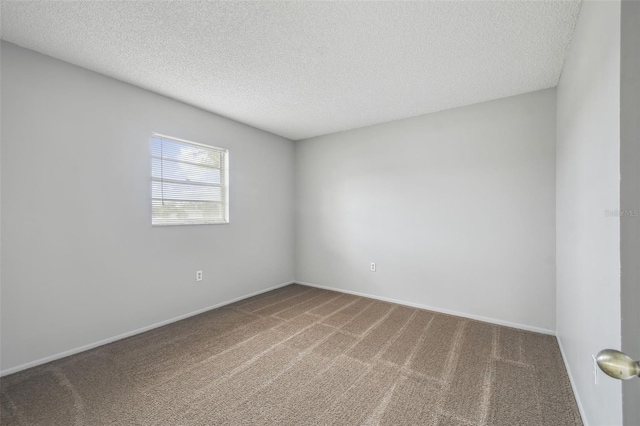 carpeted spare room with a textured ceiling