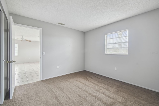 carpeted empty room with a textured ceiling and ceiling fan