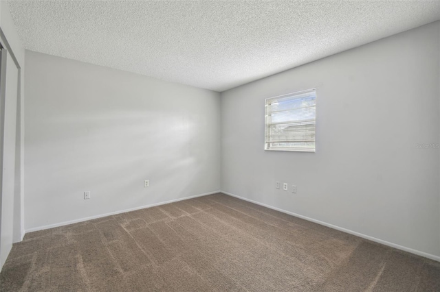 carpeted empty room with a textured ceiling