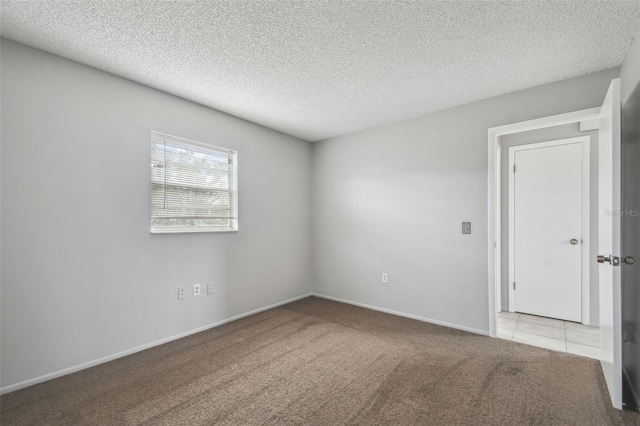 unfurnished room with a textured ceiling and light carpet