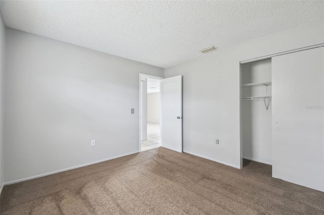 unfurnished bedroom with carpet, a textured ceiling, and a closet