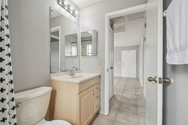 bathroom with tile patterned flooring, vanity, a textured ceiling, and toilet