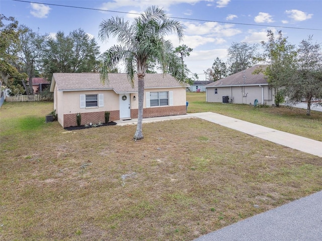 ranch-style house featuring a front yard and central AC unit