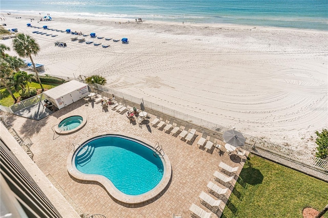 birds eye view of property featuring a water view and a beach view