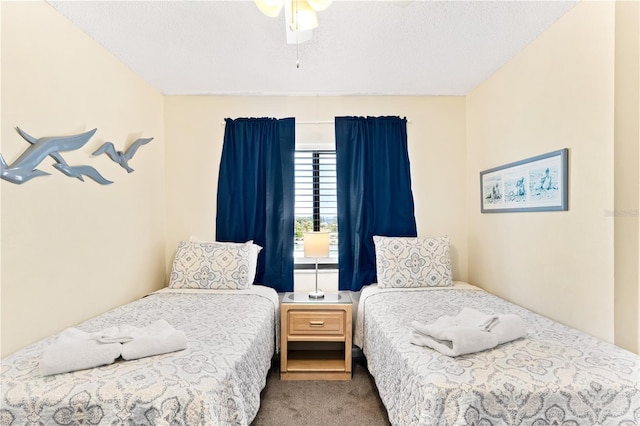 carpeted bedroom with ceiling fan and a textured ceiling