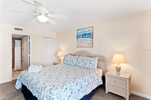 carpeted bedroom with ceiling fan, a closet, and a textured ceiling