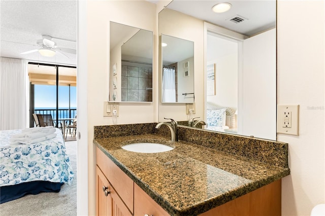 bathroom with ceiling fan, vanity, and a wall of windows