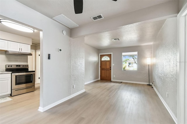 foyer featuring ceiling fan, a textured ceiling, and light hardwood / wood-style flooring