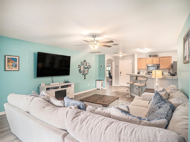 living room featuring ceiling fan and light hardwood / wood-style flooring