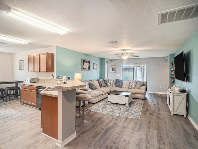 interior space featuring ceiling fan, sink, a textured ceiling, and hardwood / wood-style flooring