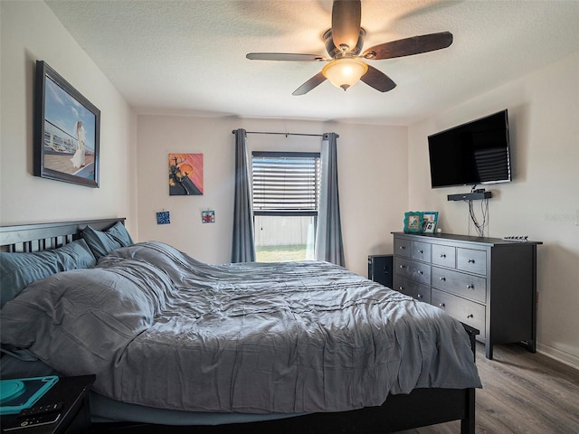 bedroom featuring hardwood / wood-style floors, ceiling fan, and a textured ceiling