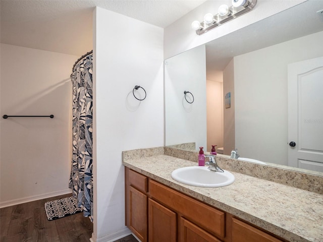 bathroom with a shower with shower curtain, vanity, and hardwood / wood-style flooring