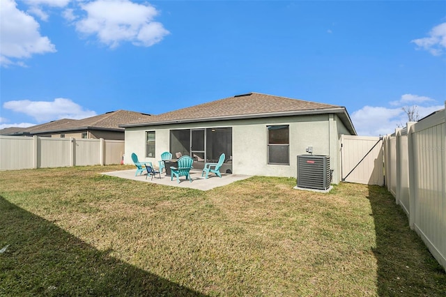 rear view of property featuring a lawn, central air condition unit, and a patio