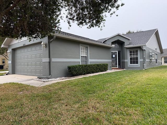 single story home featuring a front lawn and a garage