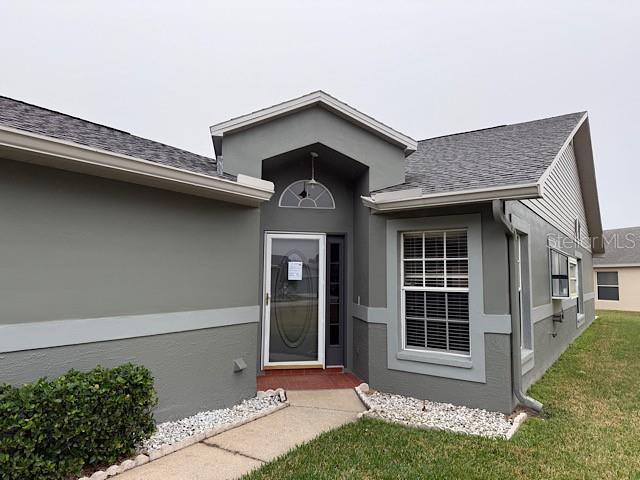 view of exterior entry with a lawn