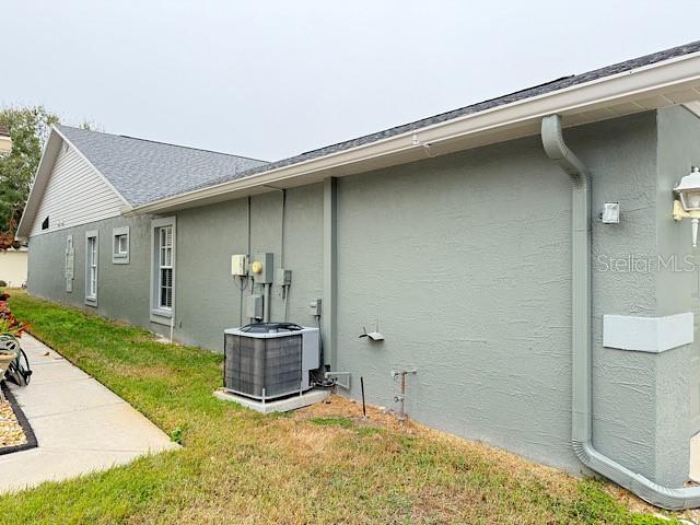 view of property exterior with a yard and central AC unit