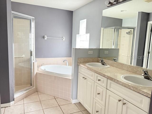 bathroom featuring tile patterned floors, vanity, and plus walk in shower