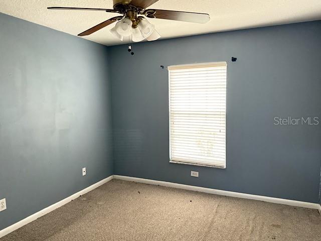 carpeted empty room with ceiling fan