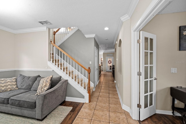 tiled foyer featuring ornamental molding