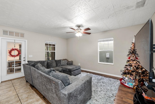 living room featuring ceiling fan, light hardwood / wood-style floors, and a wealth of natural light