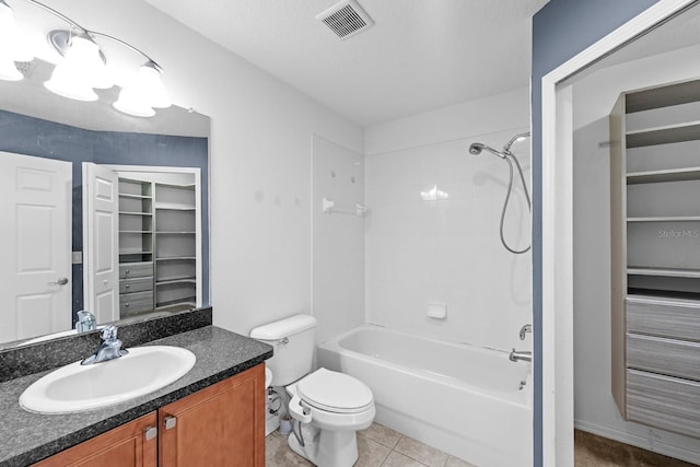 full bathroom with tile patterned floors, a textured ceiling, vanity, washtub / shower combination, and toilet