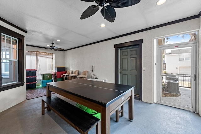 game room featuring a healthy amount of sunlight, concrete flooring, a textured ceiling, and ornamental molding