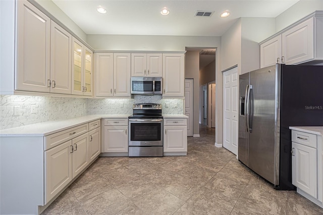 kitchen featuring decorative backsplash, white cabinetry, and stainless steel appliances