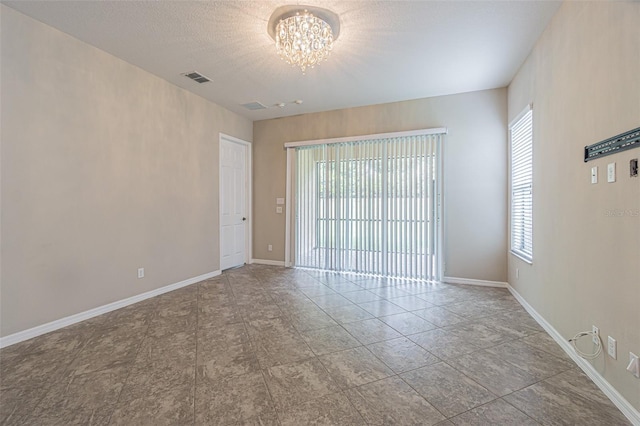 unfurnished room with a notable chandelier