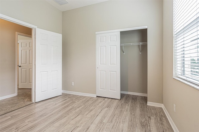 unfurnished bedroom with light wood-type flooring and a closet