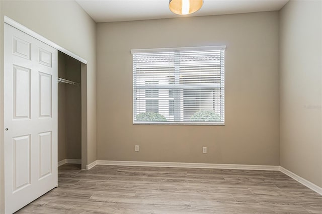 unfurnished bedroom featuring light wood-type flooring and a closet