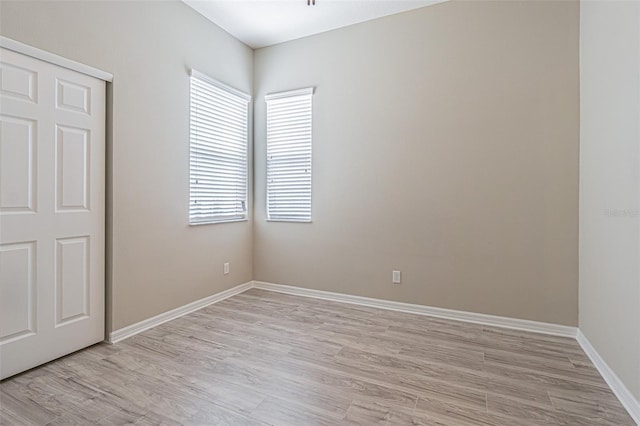 unfurnished bedroom with multiple windows and light hardwood / wood-style floors