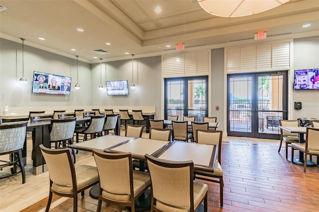 dining space featuring crown molding, french doors, and light hardwood / wood-style floors