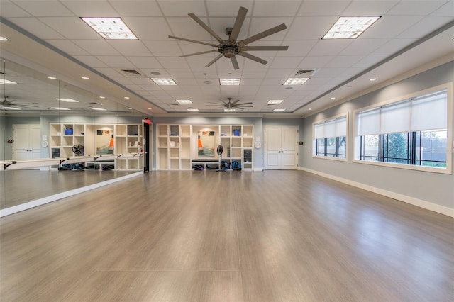 exercise room with wood-type flooring and a paneled ceiling