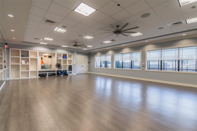 workout area with ceiling fan, a drop ceiling, and wood-type flooring