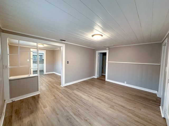 unfurnished room featuring light hardwood / wood-style floors and crown molding