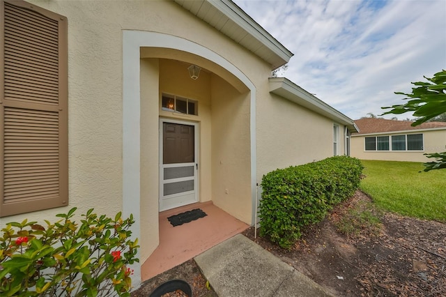 entrance to property featuring a yard