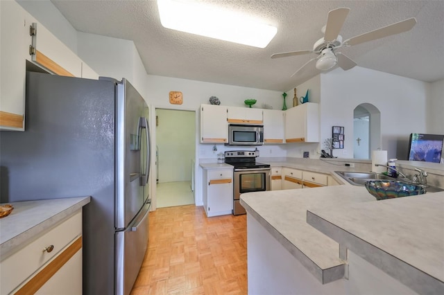 kitchen featuring white cabinetry, sink, ceiling fan, a textured ceiling, and appliances with stainless steel finishes